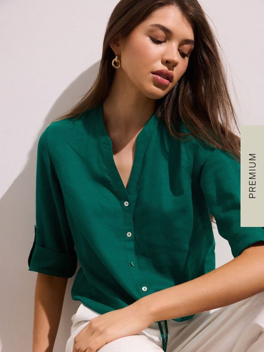 Baner promujący odzież sportową: kobieta w czarnym zestawie fitness z rozpinaną bluzą i legginsami, prezentująca strój w pozycji stojącej i siedzącej