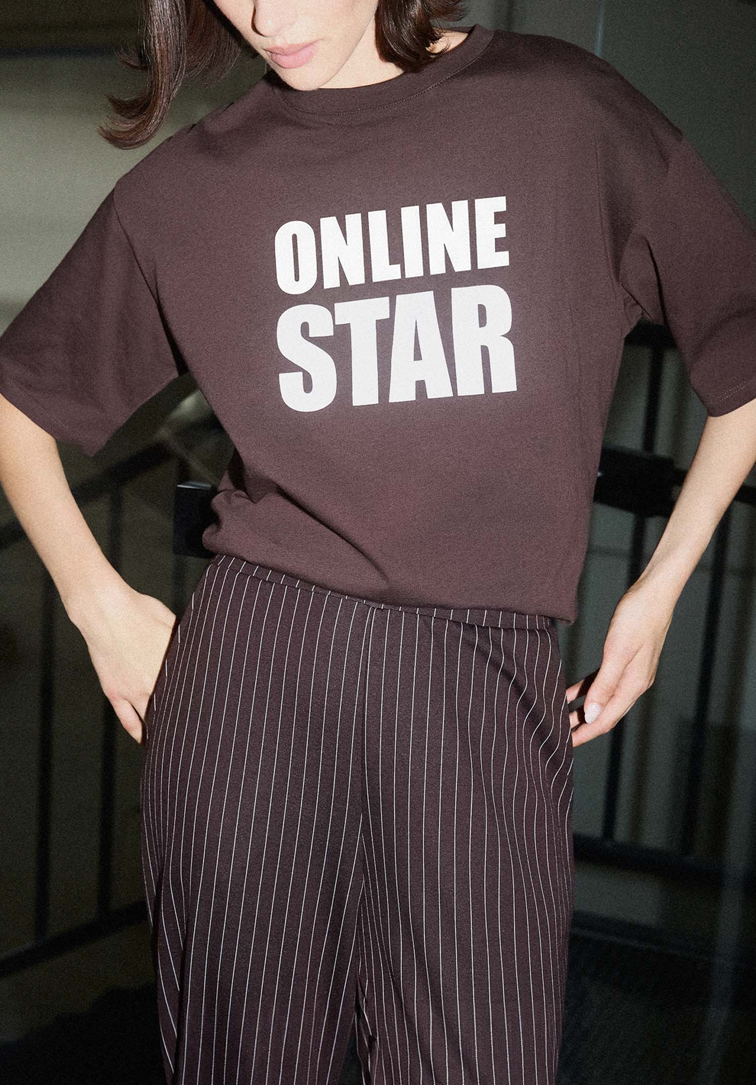 kobieta w brązowej koszulce z napisem online star